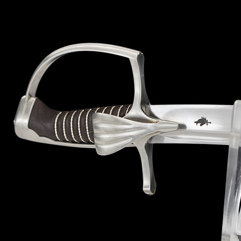 Close-up of a sword with a silver hilt and black grip on a black background