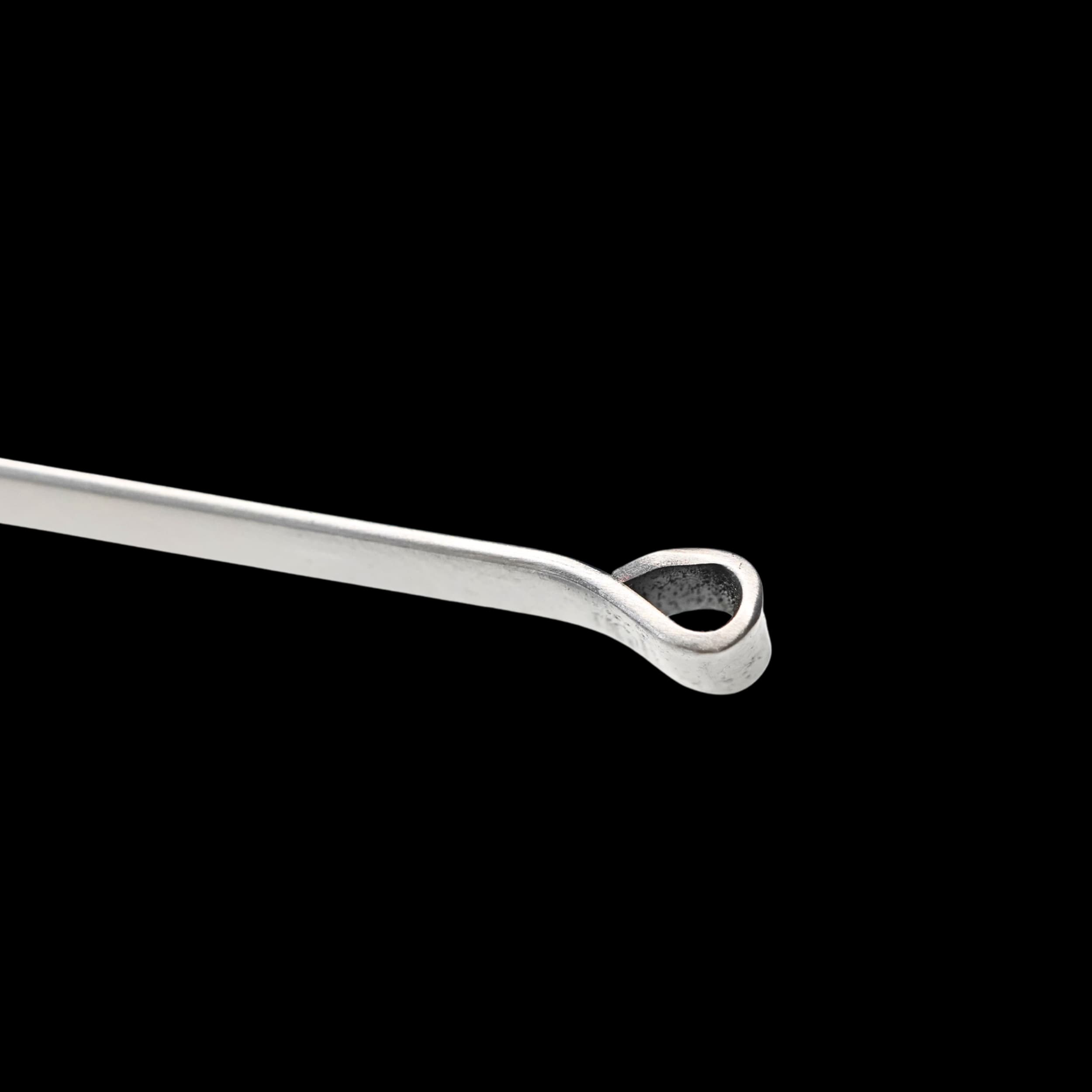 Metallic tool with a curved design on a black background