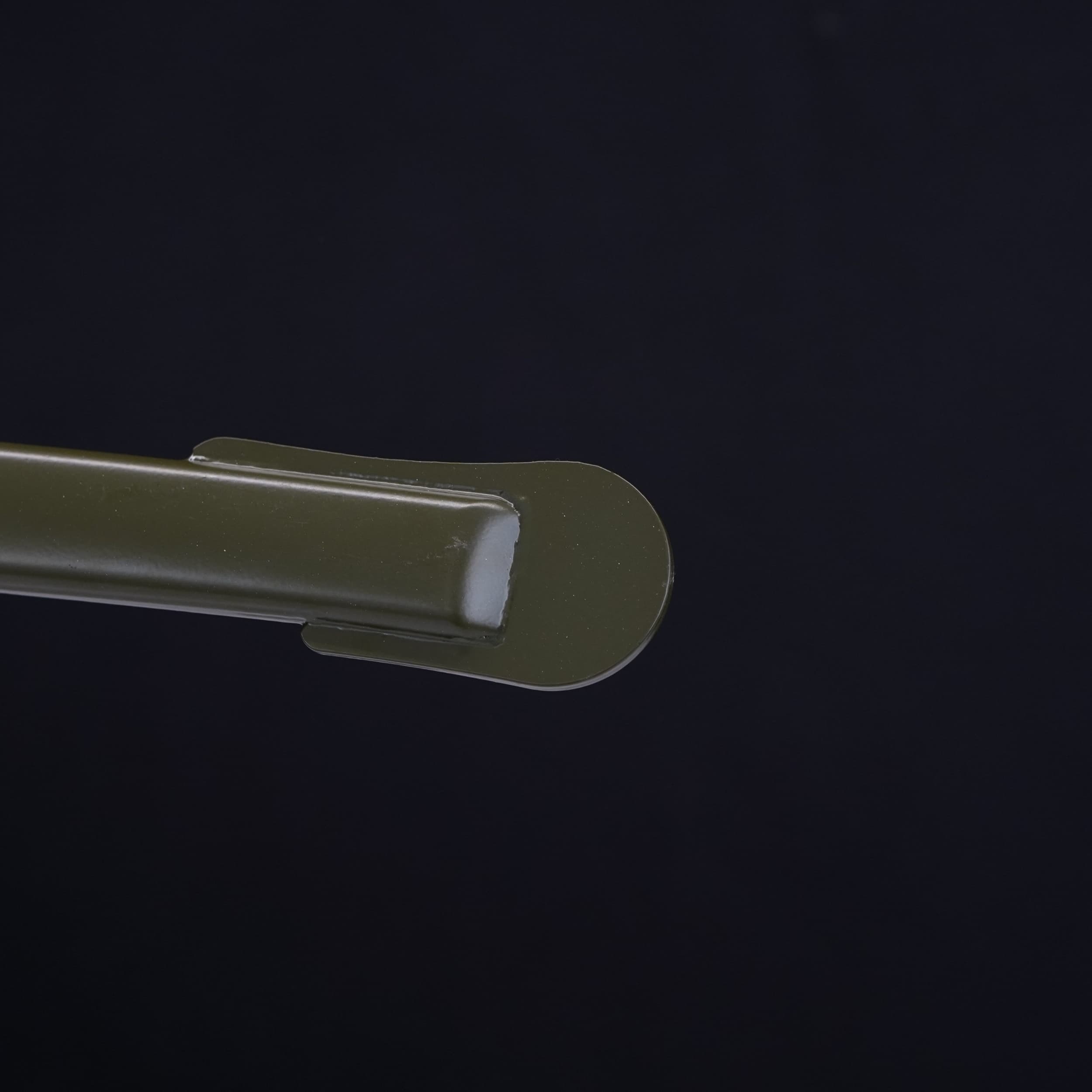 Close-up of a green plastic clip on a black background