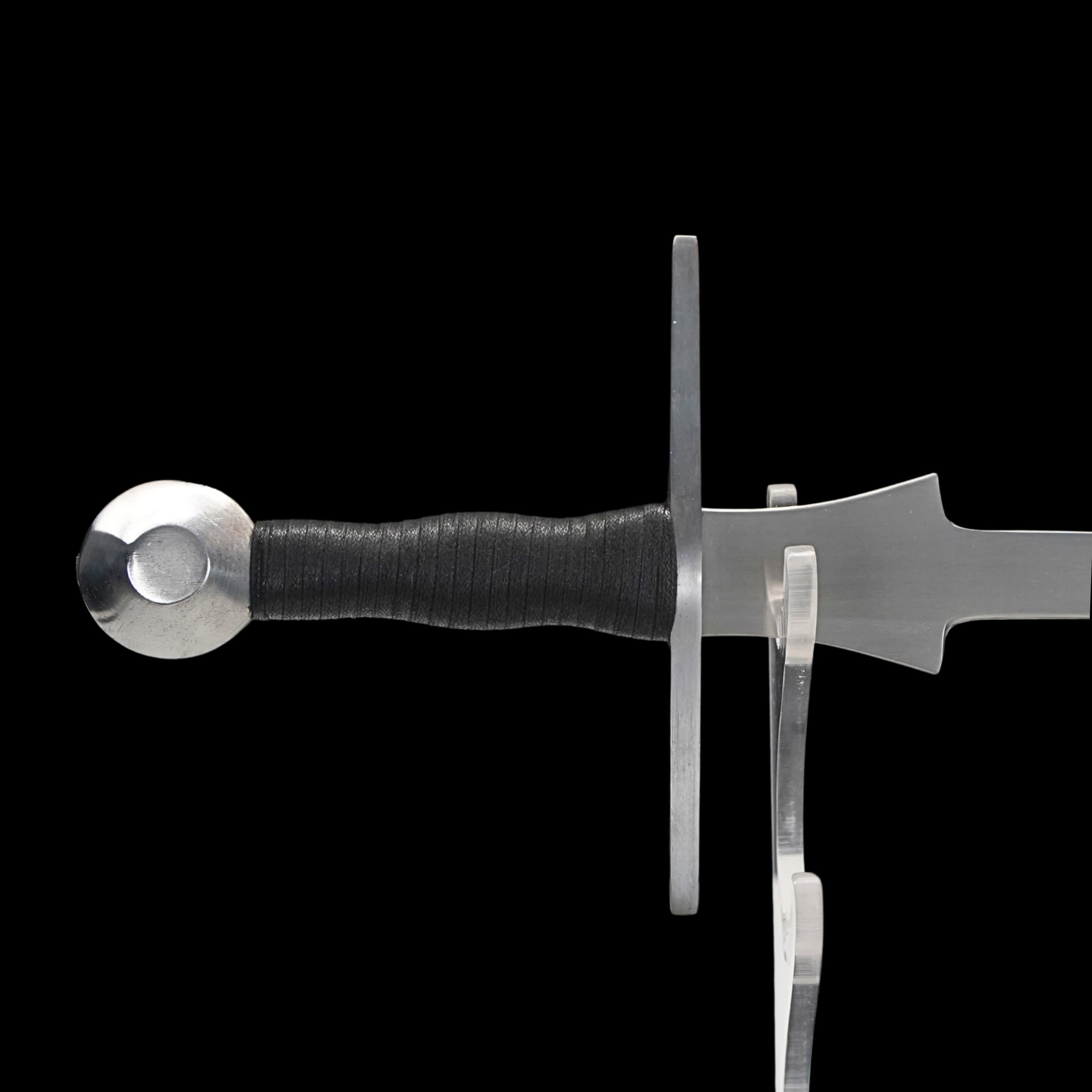 Sword with black handle on a clear stand against a white background