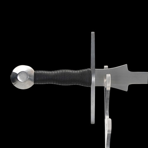 Sword with black handle on a clear stand against a white background