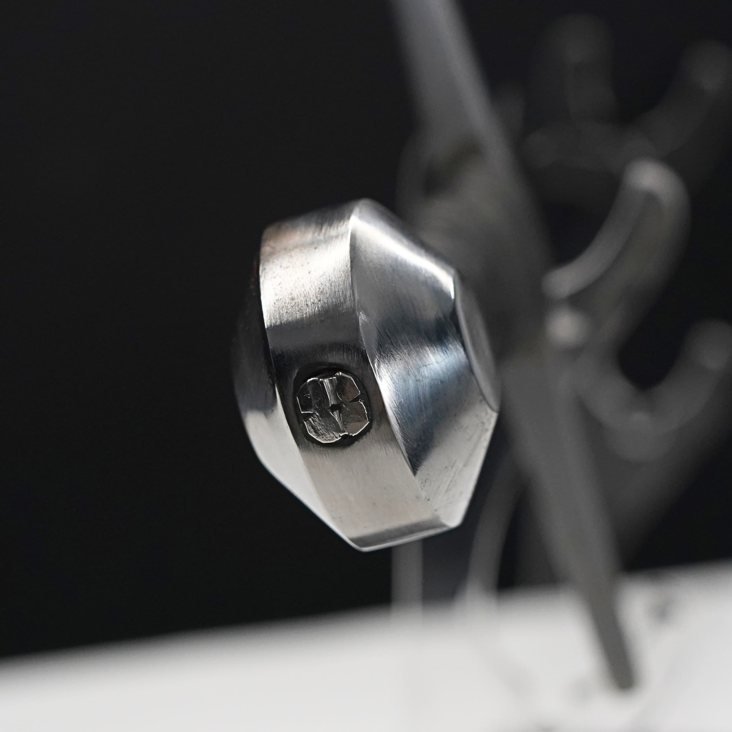Close-up of a metallic hexagonal bolt on a dark background