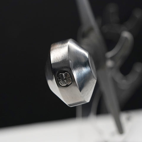 Close-up of a metallic hexagonal bolt on a dark background