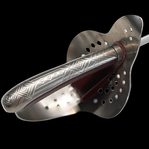 Metallic object with intricate designs on a black background