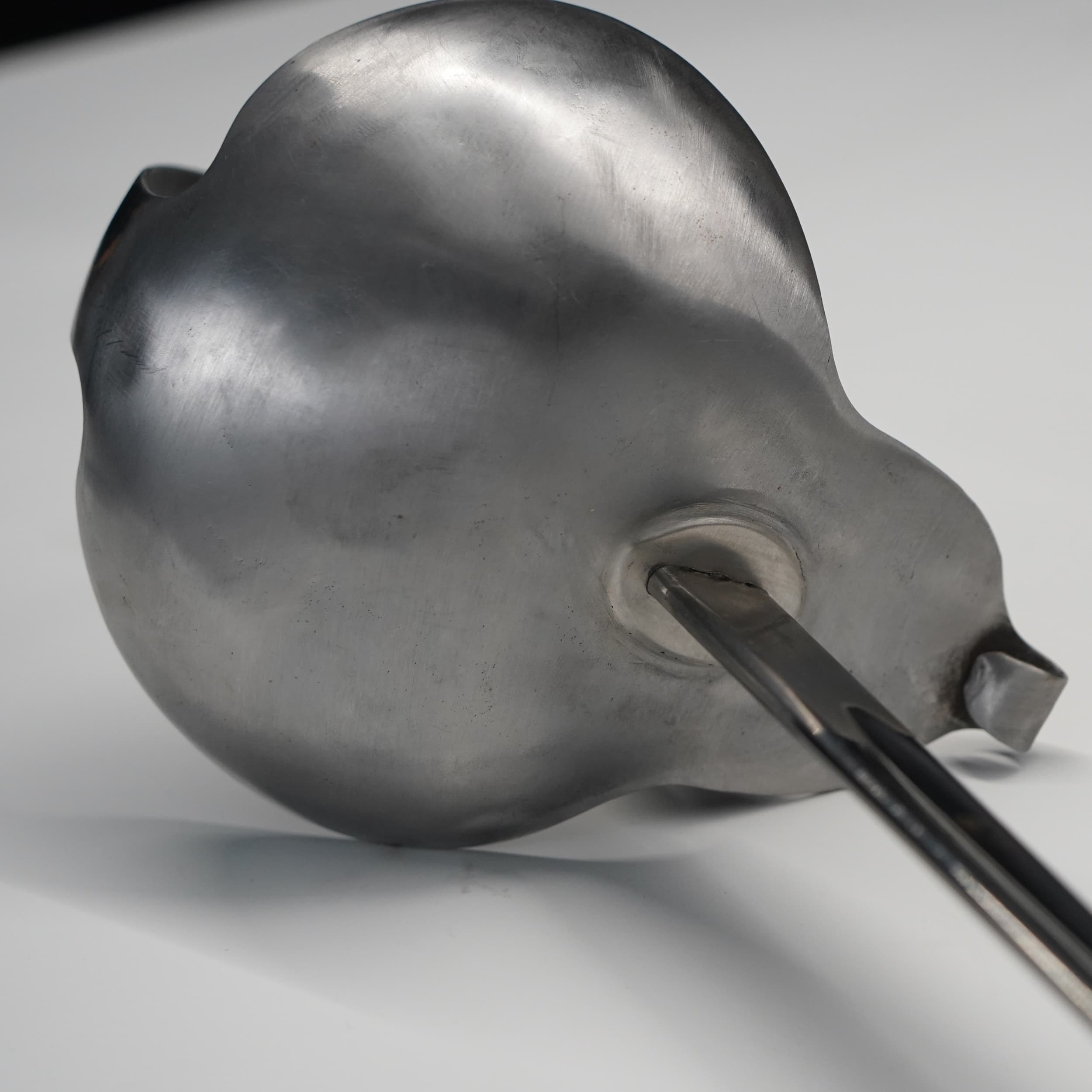 Metallic ladle on a gray background