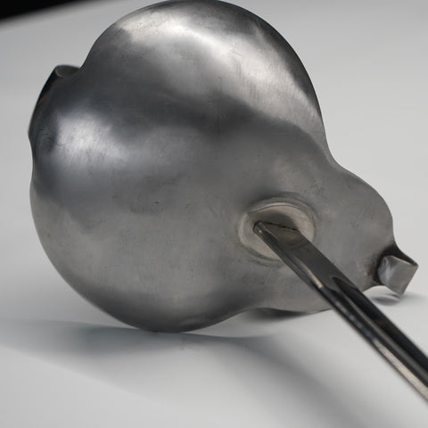 Metallic ladle on a gray background