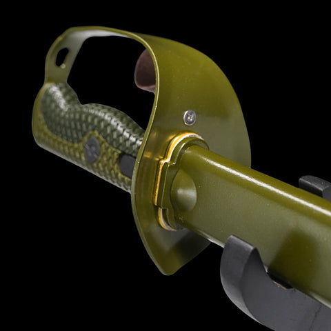 Close-up of a green tool with a metallic handle on a black background