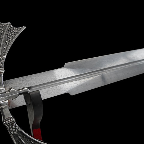 Close-up of a sword with detailed hilt on a black background