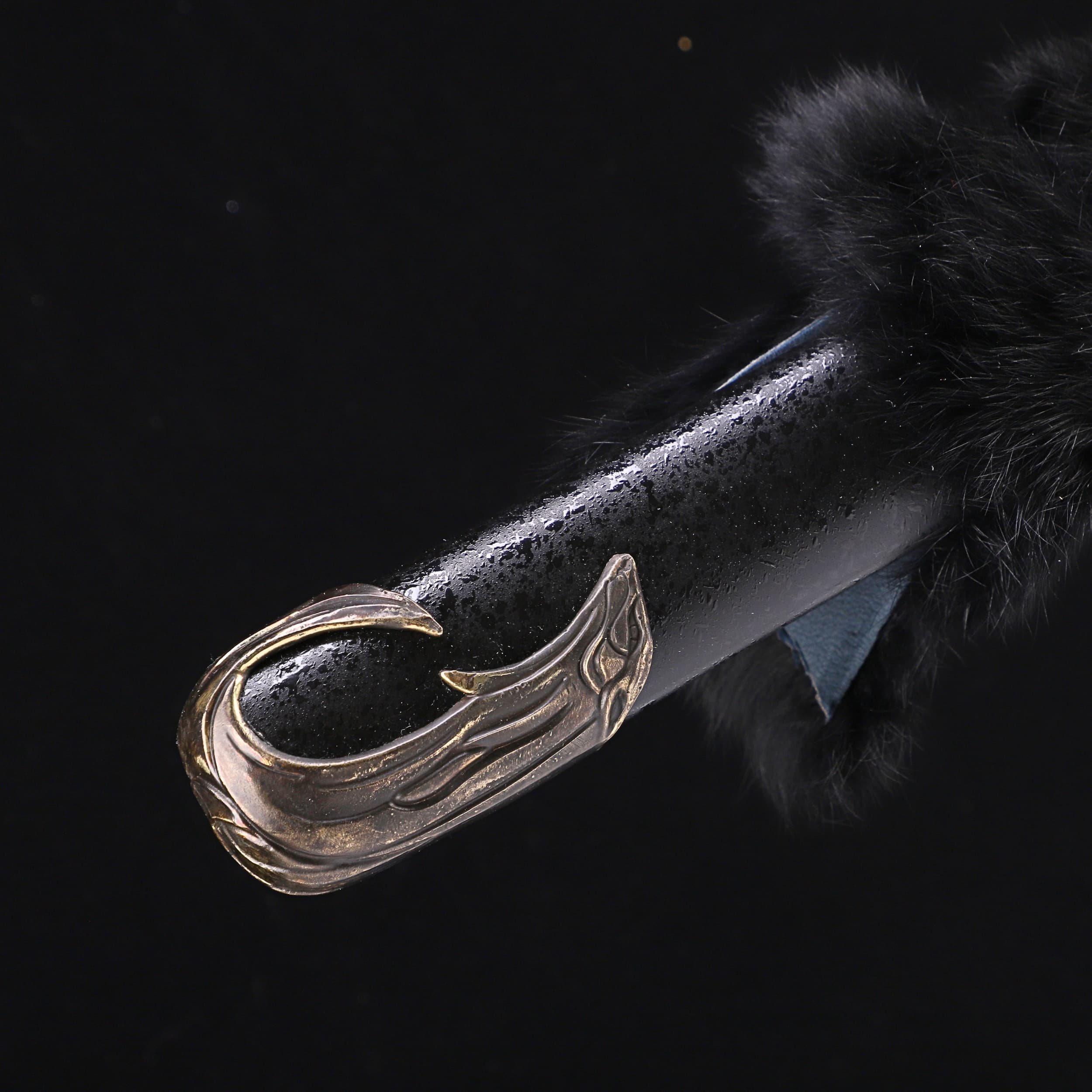 Decorative handle with a winged design on a dark background