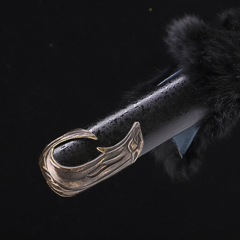 Decorative handle with a winged design on a dark background
