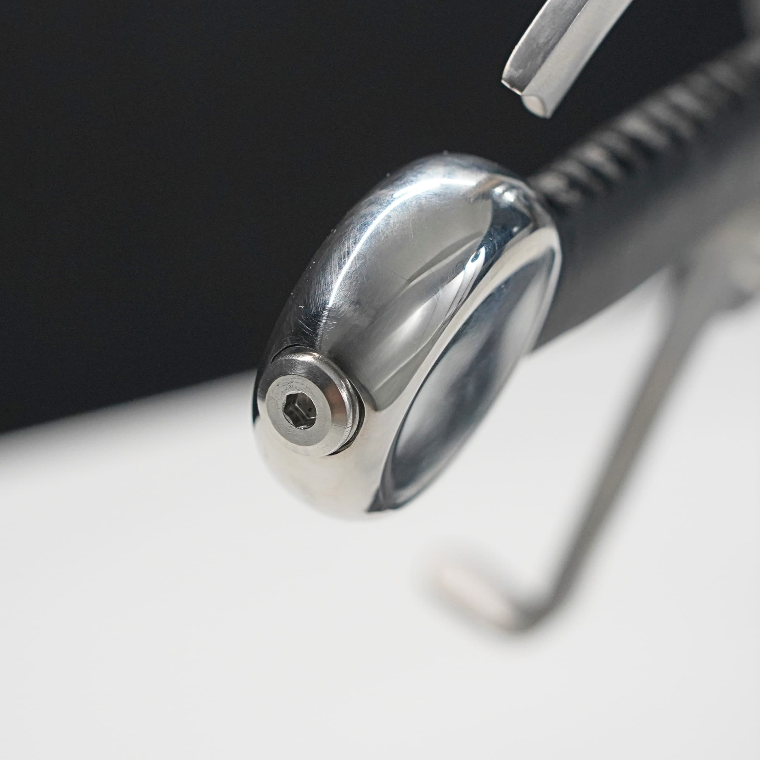 Close-up of a metallic pen cap on a white surface