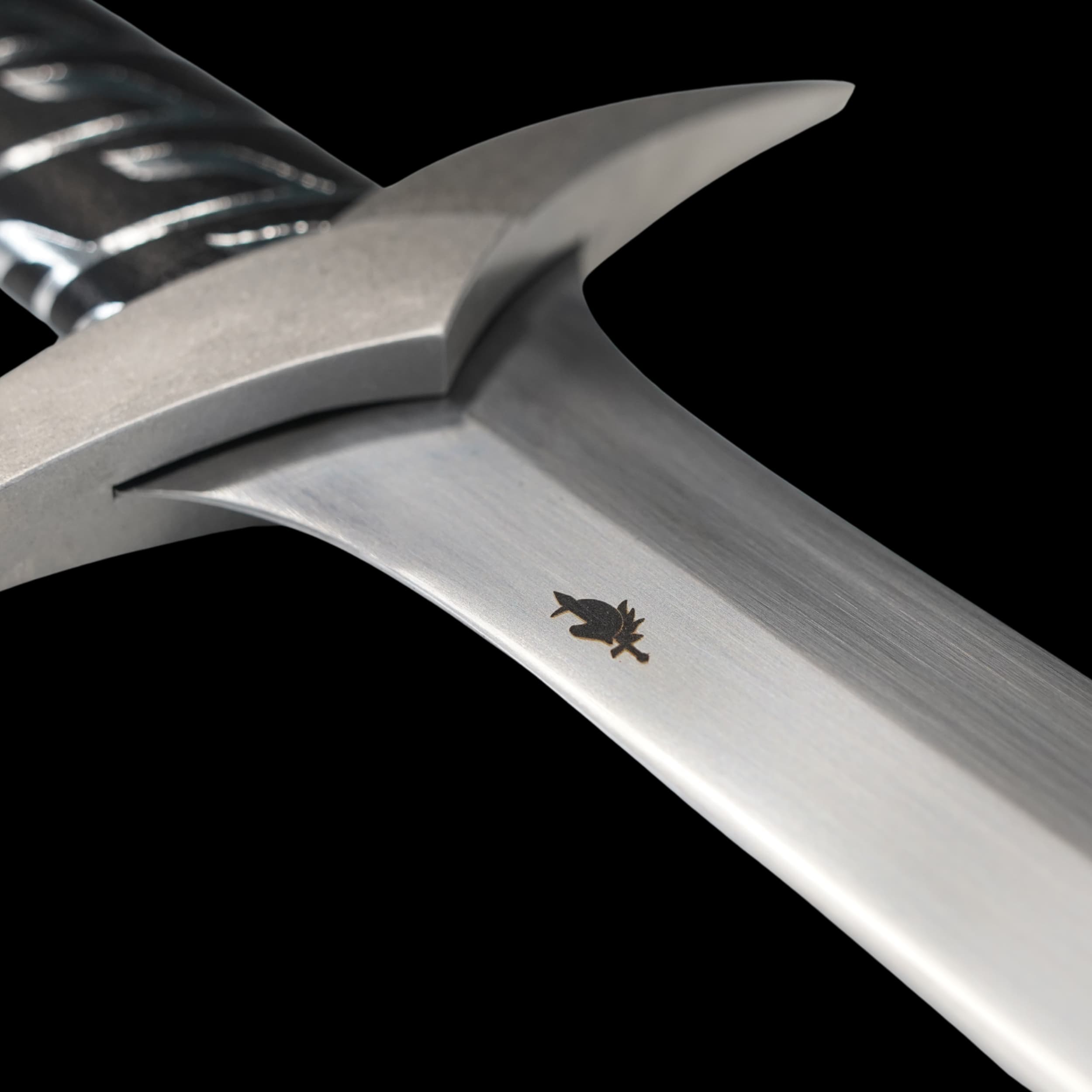 Close-up of a metallic tool with a brand logo on a black background