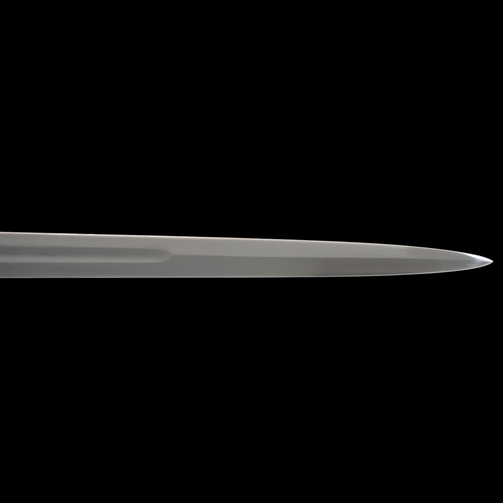 Long, thin metallic object on a black background